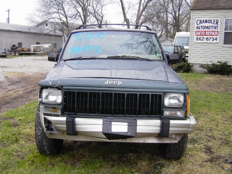 1993 Jeep Cherokee - Front view of a 1993 Jeep Cherokee with visible damage to the front bumper and a cracked headlight.