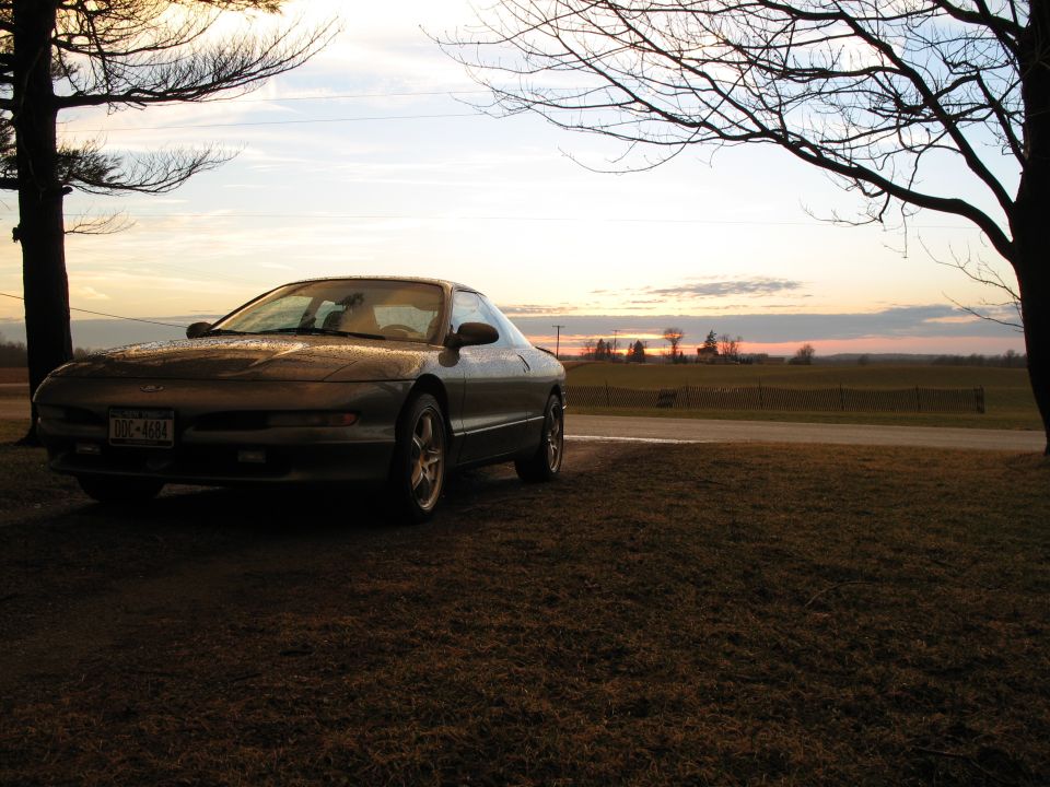 1996 Ford Probe 3q-front view, dark color, parked outdoors at sunset