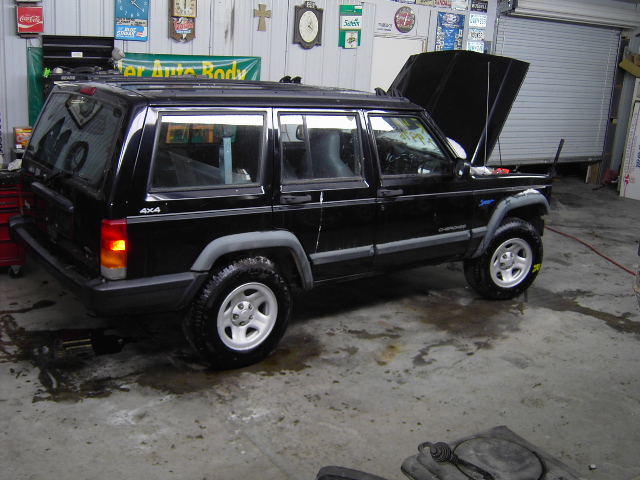 Black 1998 Jeep Cherokee 3/4 front view with hood open in garage