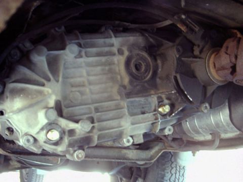 1988 Ford Bronco - Underside view of a vehicle's transmission, showing various bolts and components.