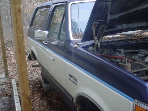 1988 Ford Bronco - This two-tone Ford Bronco, likely from the late 1980s, is shown with its hood open in an outdoor setting.