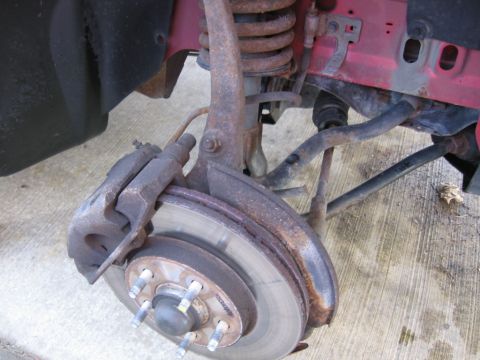 1995 Ford Thunderbird - Close-up view of a rusty front suspension and brake assembly, with the Supermotors.net logo in the corner.