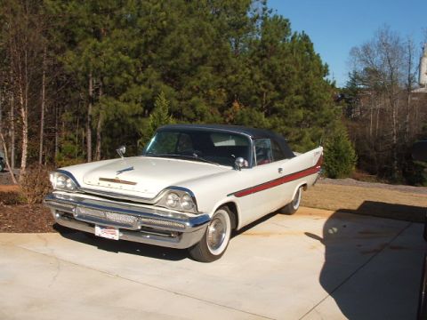 1966 Ford Ranchero - A classic white convertible with a red stripe and black top sits parked outdoors.