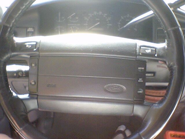 1994 Ford Bronco interior showing steering wheel with cruise control buttons and dashboard gauges