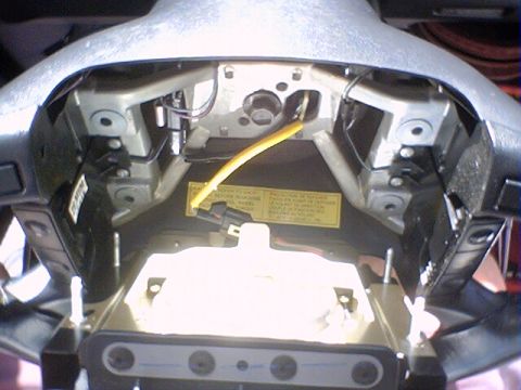 1994 Ford Bronco - Interior view of a vehicle's steering column, showing wiring and a warning label.