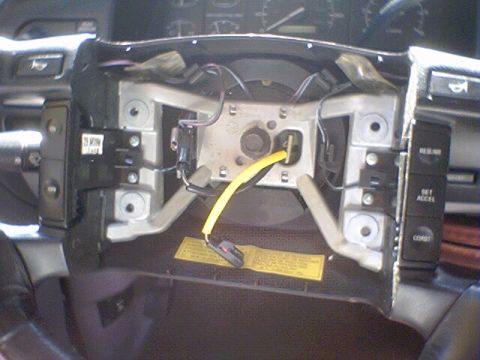 1994 Ford Bronco - The steering column's clock spring assembly is exposed, revealing internal wiring and mounting hardware.
