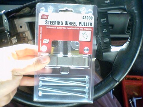 1994 Ford Bronco - A steering wheel puller tool kit is shown, with the car's interior visible in the background.