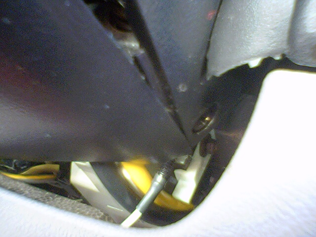 close-up of wiring and plastic trim inside a vehicle, with a Supermotors.net logo in the corner