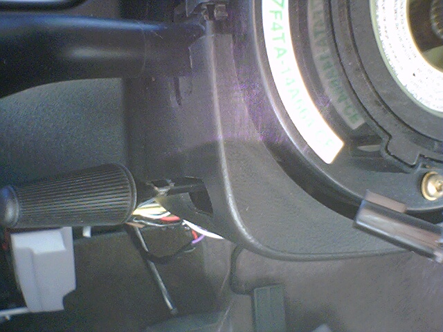 Close-up of car's steering column with clock spring and wiring visible