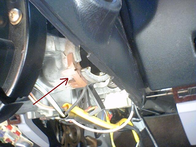 Close-up of a vehicle's steering column showing the clock spring assembly with wiring