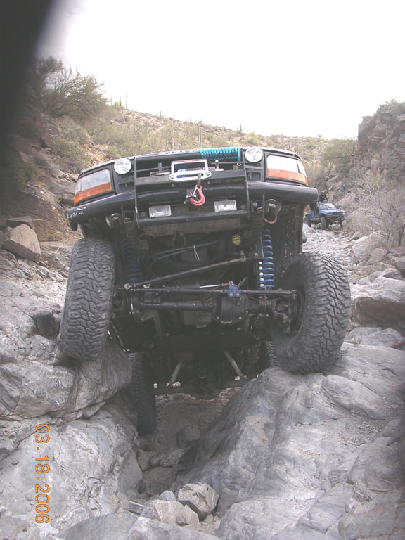 Black Ford Bronco navigating a rocky off-road trail, front view