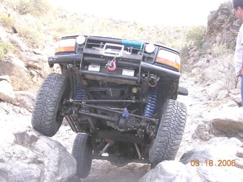 1994 Ford Bronco - Modified 1994 Ford Bronco navigating a rocky trail with its front wheels angled.