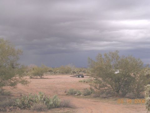 1994 Ford Bronco - A trailer sits in a dry, desert landscape with cacti and scrub brush under a stormy sky.