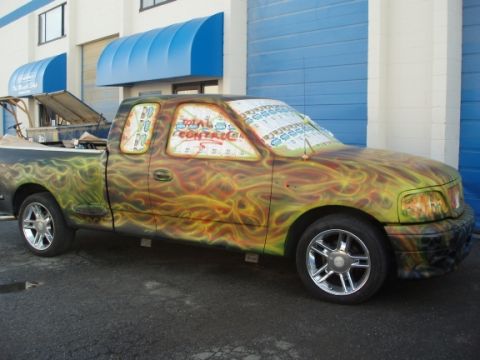 1985 Ford Bronco II - This customized pickup truck features a flame airbrush design and text on its windows.