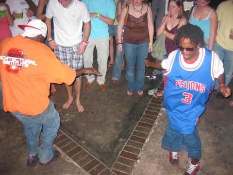 1989 Ford Bronco - A group of people are dancing on a paved area with brick trim.