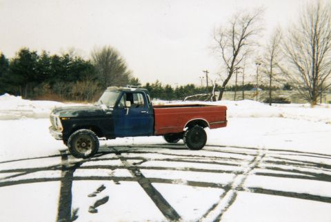 1994 Ford Bronco - This Ford F-Series pickup truck has a blue front and a red rear, seen in the snow.