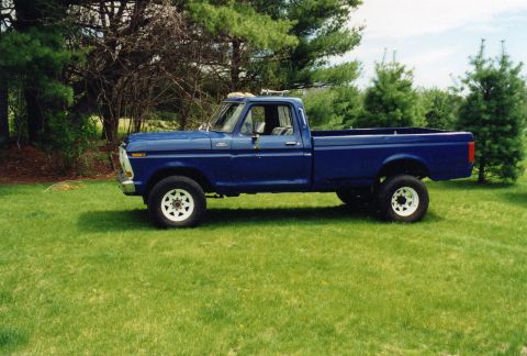 1994 Ford Bronco - This blue pickup truck, likely from the 1970s, is shown from the side view.