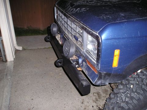 1986 Ford Bronco II - Front view of a blue SUV's aftermarket bumper and grille, showing auxiliary lights and tow hooks.