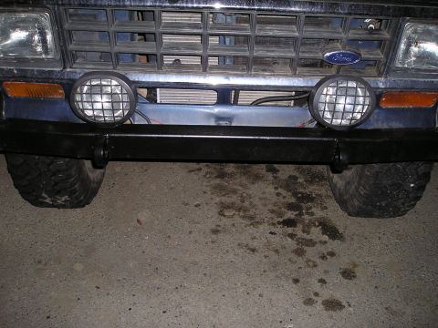 1986 Ford Bronco II - Close-up of a Ford truck's front end, showing the grille, headlights, and bumper with auxiliary lights.