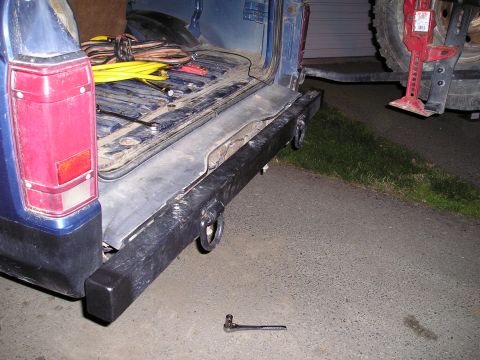1986 Ford Bronco II - Rear view of a blue SUV's cargo area and aftermarket bumper, with tools visible.