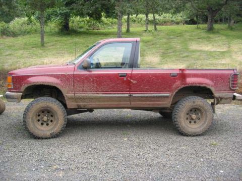 1991 Ford Explorer - Modified 1991 Ford Explorer pickup conversion with lifted suspension sits on gravel.