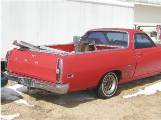 1972 Ford Ranchero - Rear view of a red 1972 Ford Ranchero pickup truck with some items in the bed.