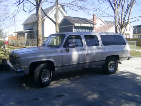 1985 Ford Bronco - This GMC Suburban is parked in front of a residential house on a sunny day.