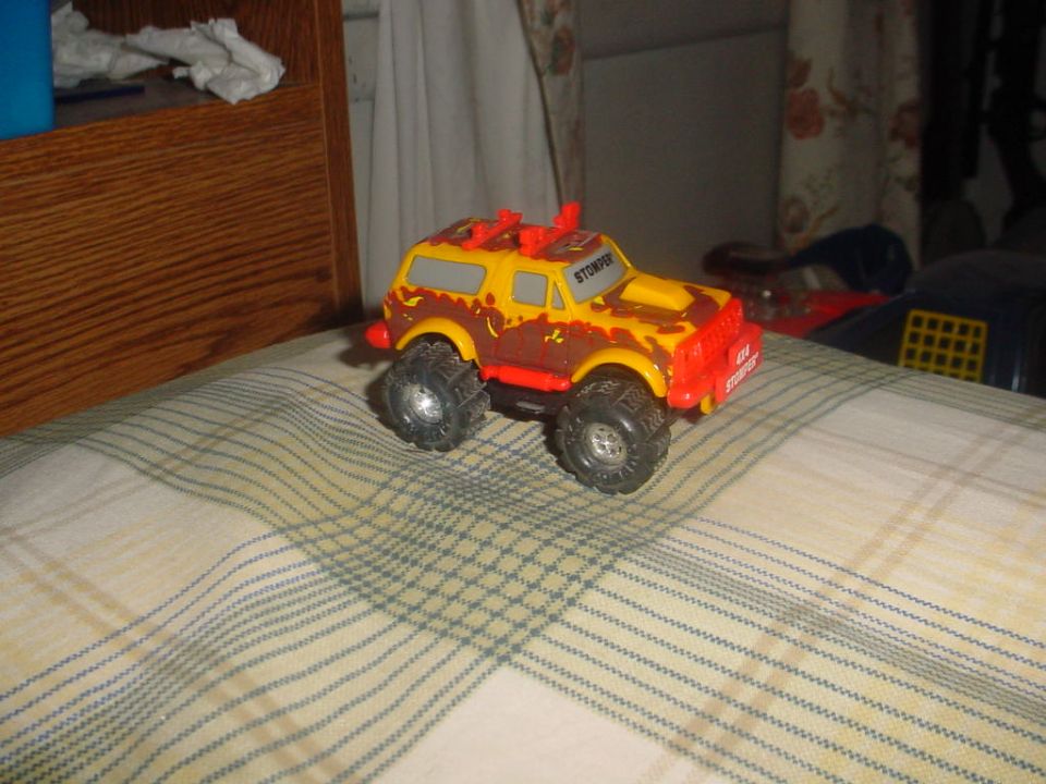 Yellow and brown toy truck with red accents and large tires
