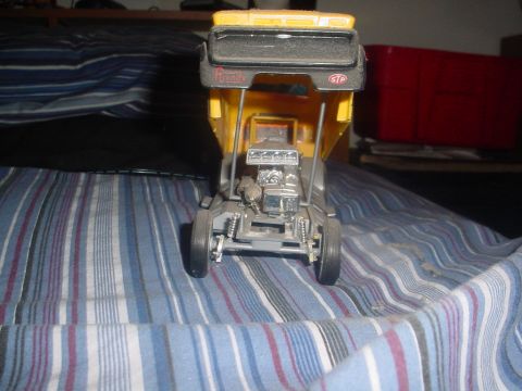 1988 Ford Bronco - A model dump truck with a visible engine is photographed indoors on a striped surface.