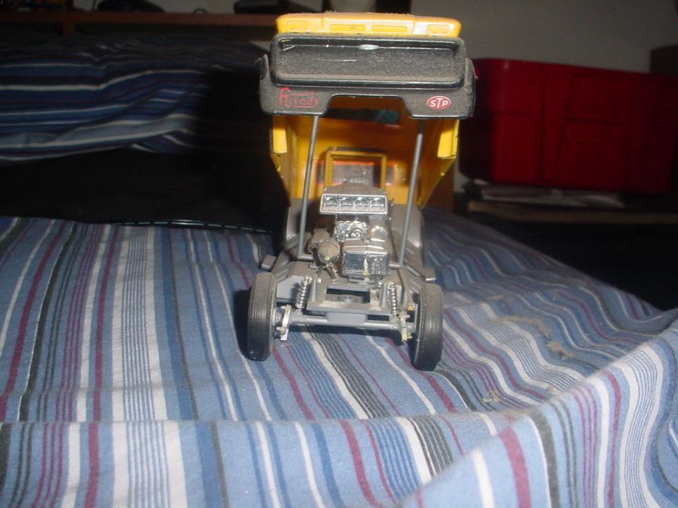 model dump truck with chrome engine and yellow bed, sitting on striped fabric