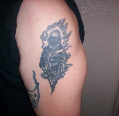 1970 Mercury Cougar - A tattoo depicts a figure surrounded by flames, with another tattoo of a mask visible on the arm.