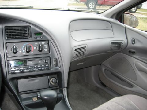 1995 Ford Thunderbird - The interior dashboard features a digital clock and an aftermarket stereo system.