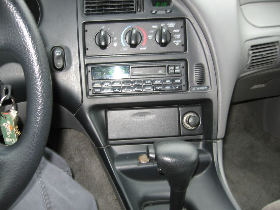 1995 Ford Thunderbird interior dashboard showing steering wheel, radio, climate controls, and gear shifter