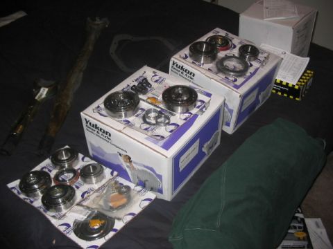 1991 Ford Bronco - Several boxes and loose parts from Yukon Gear & Axle are spread out, likely for a vehicle repair or upgrade.