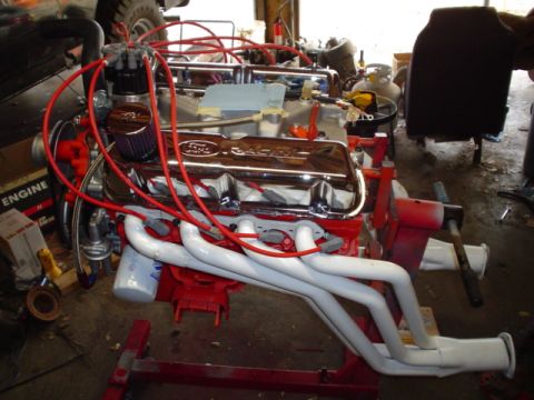 1981 Ford Bronco - Ford V8 engine with chrome valve covers and red spark plug wires on an engine stand.