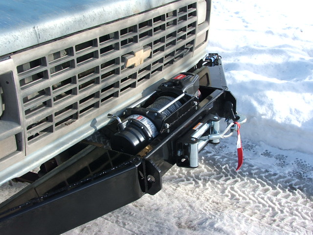 Black winch mounted in a custom black tube bumper on a square-body Chevy