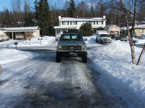 1990 Chevrolet Suburban - Chevrolet Suburban in a snowy driveway with other vehicles in the background.