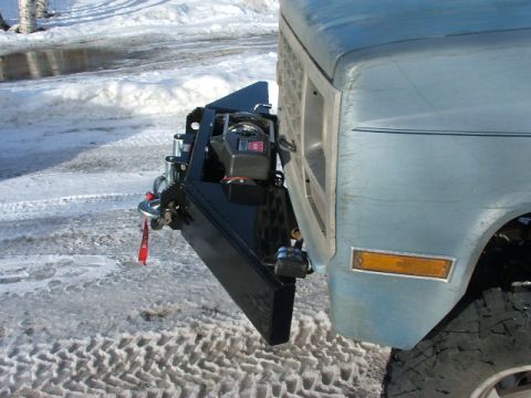 1990 Chevrolet Suburban - A custom front bumper with a winch is attached to a light blue truck in a snowy environment.