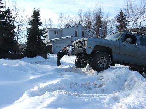 1990 Chevrolet Suburban - Modified 1990 Chevrolet Suburban navigating a snowy driveway with a person leaning against it.