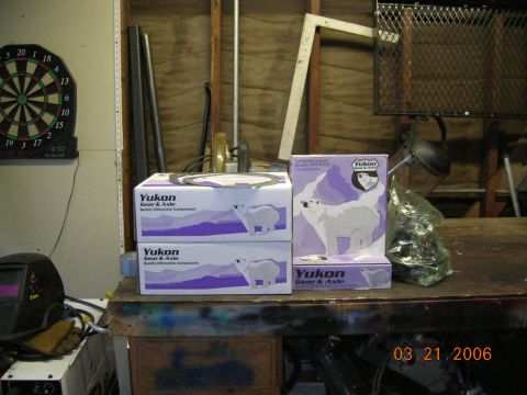 1985 Ford Bronco - Yukon Gear & Axle parts boxes and a welding mask on a workbench. Photo dated 03.21.2006.