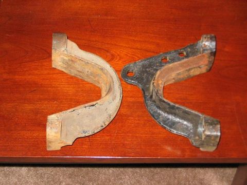 1991 Ford Bronco - Two aged and corroded automotive suspension components are displayed on a polished wooden table.