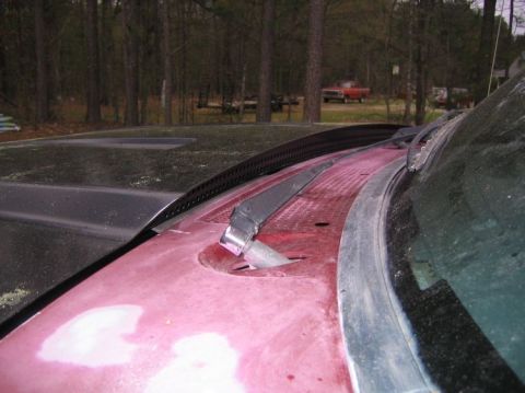 1992 Ford F-150 - View of a vehicle's hood and windshield base, with a distant red truck in the background.