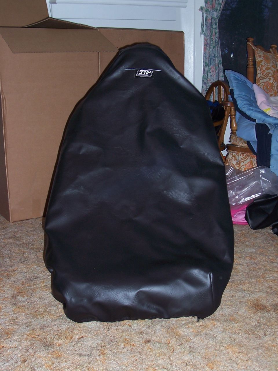 Black PRP seat cover on a car seat, indoors