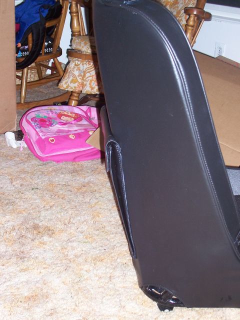 1988 Suzuki Samurai - A black car seat is shown in a room with a pink backpack and rocking chair.