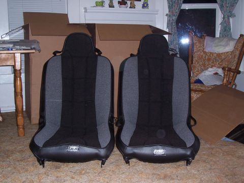 1988 Suzuki Samurai - A pair of aftermarket car seats are shown indoors, with boxes and furniture in the background.