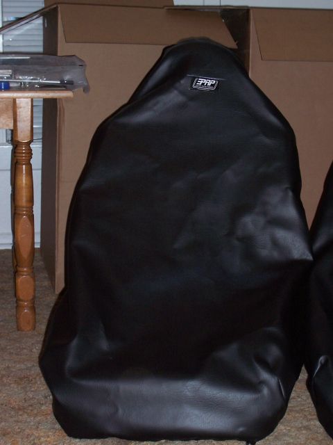 1988 Suzuki Samurai - Two black seat covers are shown, one with a visible PRP logo, in front of cardboard boxes.
