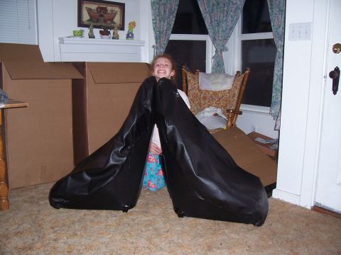 1988 Suzuki Samurai - Two black car seats are the focus, with a child seated between them and large boxes in the background.