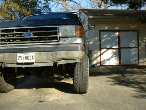 1991 Ford Bronco - Front view of a 1991 Ford Bronco parked in front of a garage.