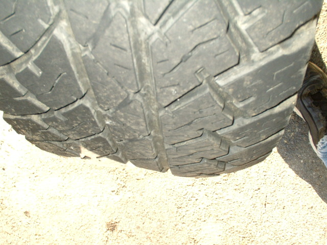 Close-up of all-terrain tire tread wear on the driver-side front tire