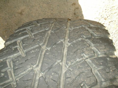 1991 Ford Bronco - A tire with a nail protruding from the tread.